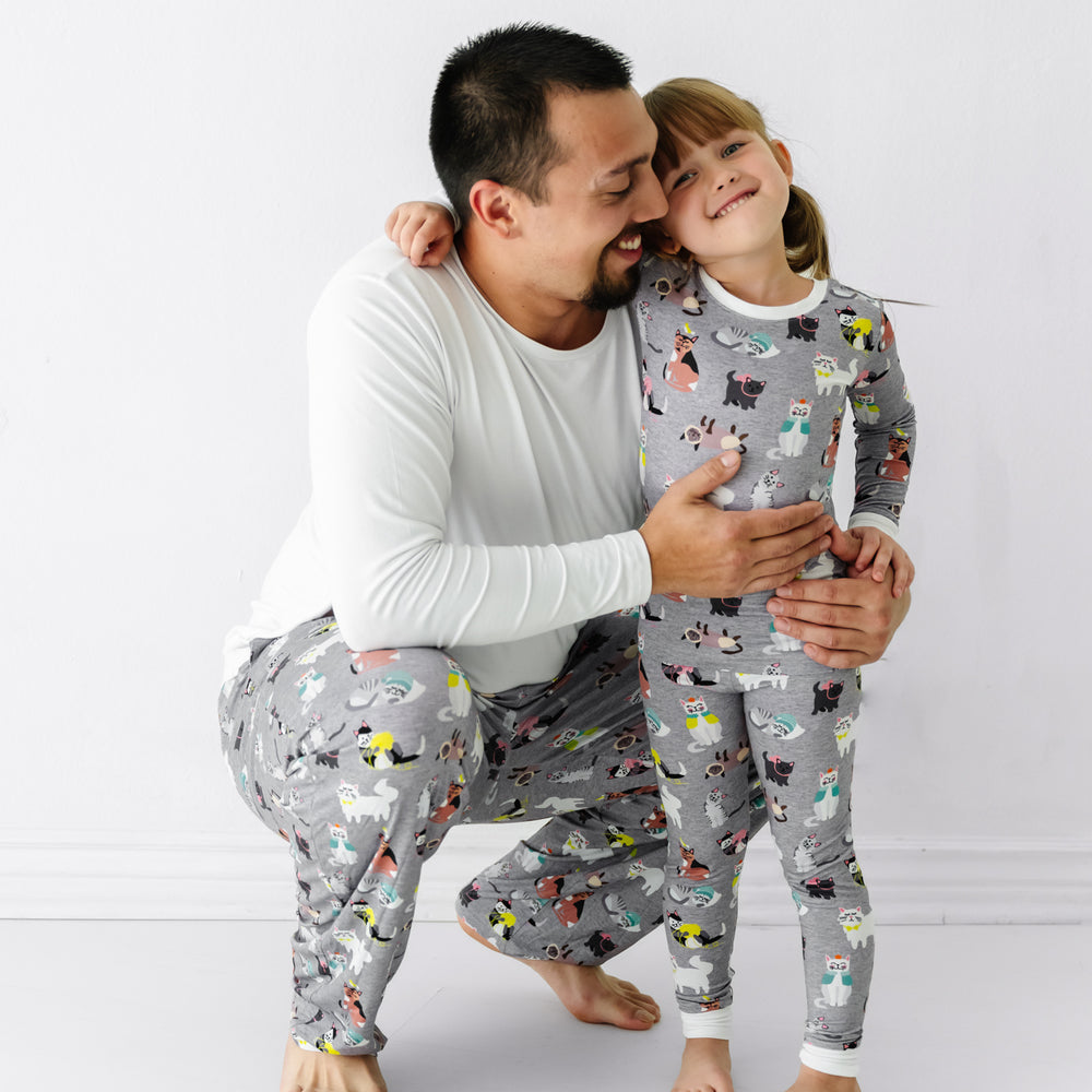 Father and daughter wearing matching Cozy Cats pajamas