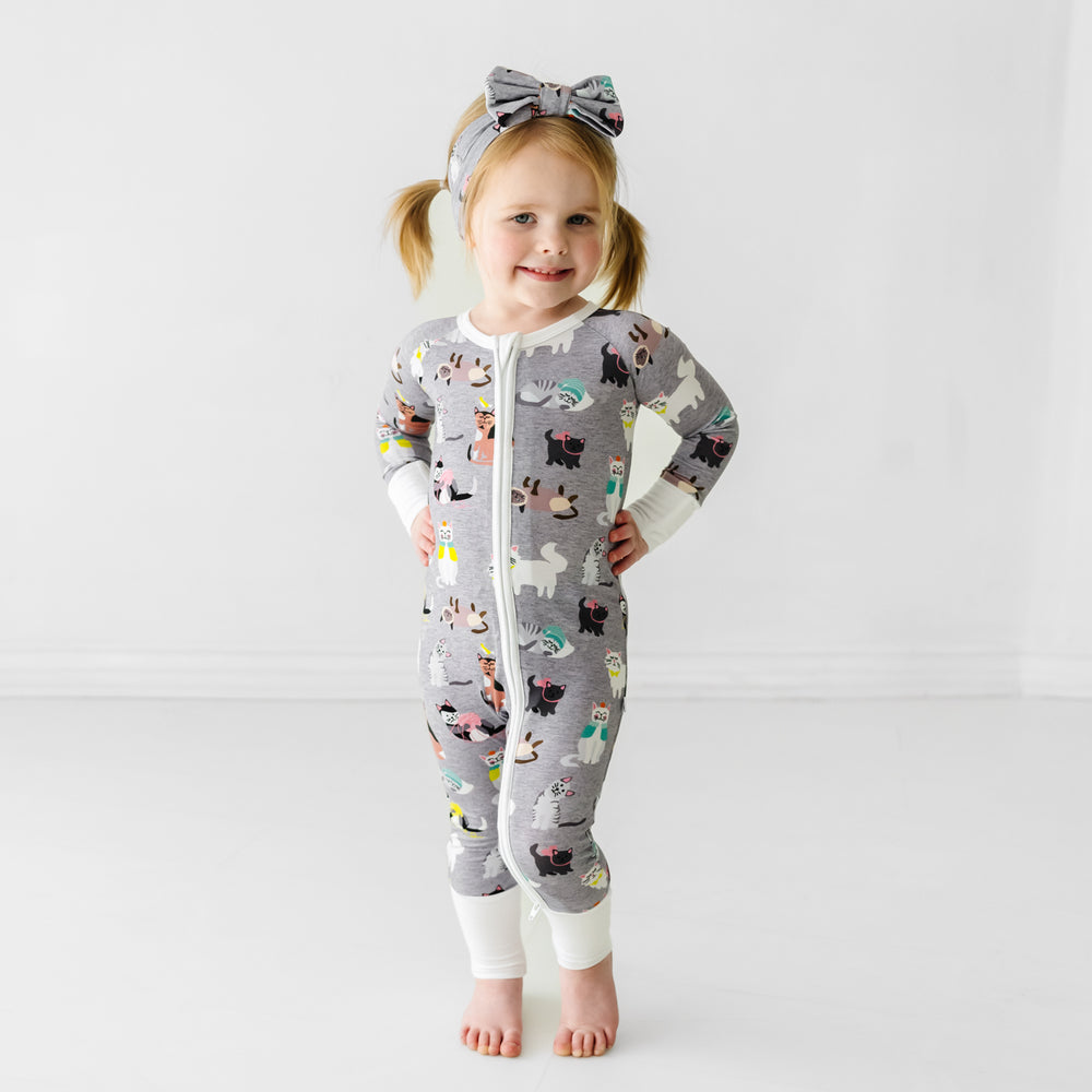 Child wearing a Cozy Cats luxe bow headband and matching zippy
