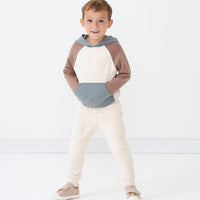Child with their hands in their pocket wearing Cream joggers and coordinating Colorblock pullover hoodie