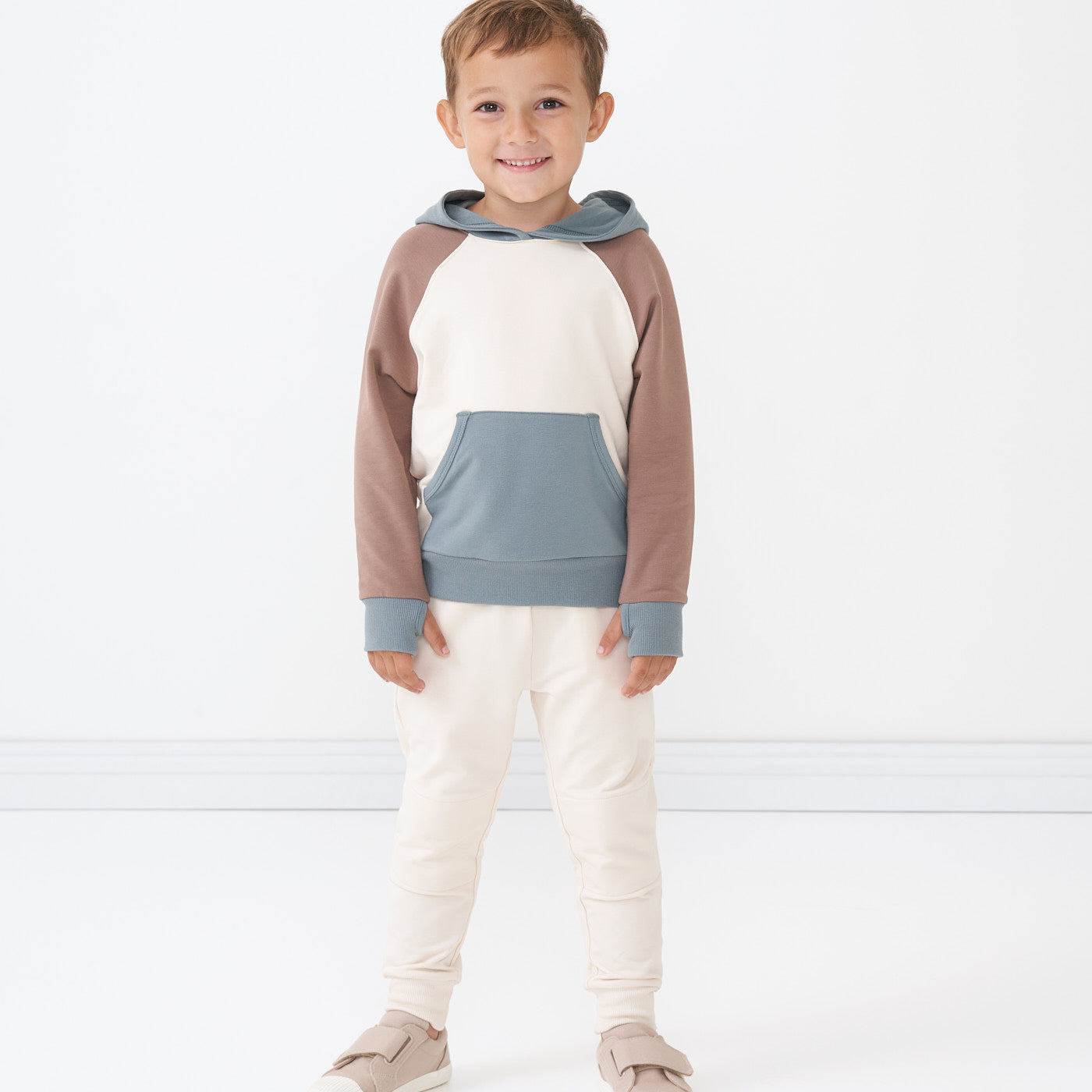 Child wearing Cream joggers and coordinating Colorblock pullover hoodie