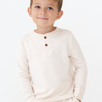 Alternate close up image of a child wearing a Cream henley tee