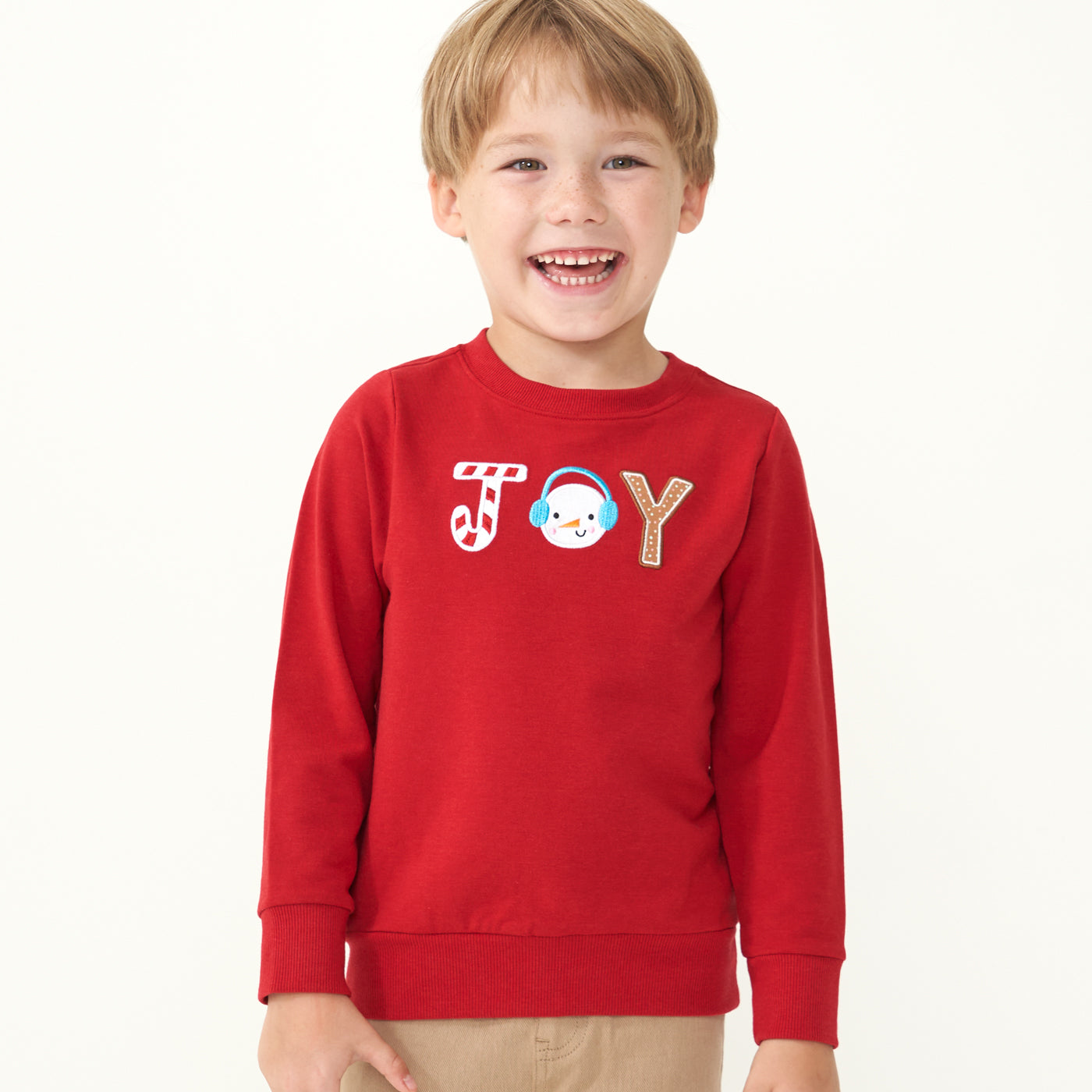 Child wearing a Holiday Red Joy crewneck 