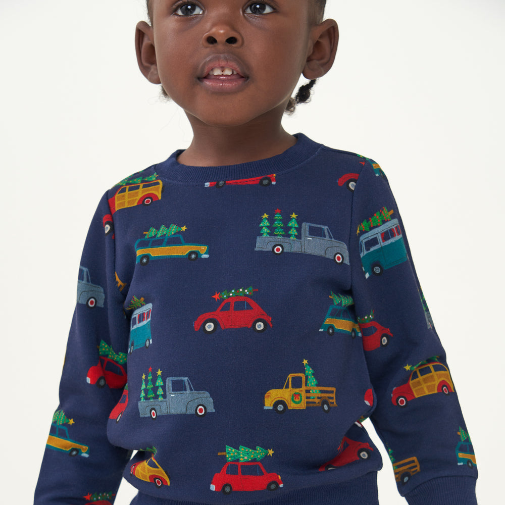 Close up image of a child wearing a Tree Traffic crewneck sweatshirt detailing the pattern