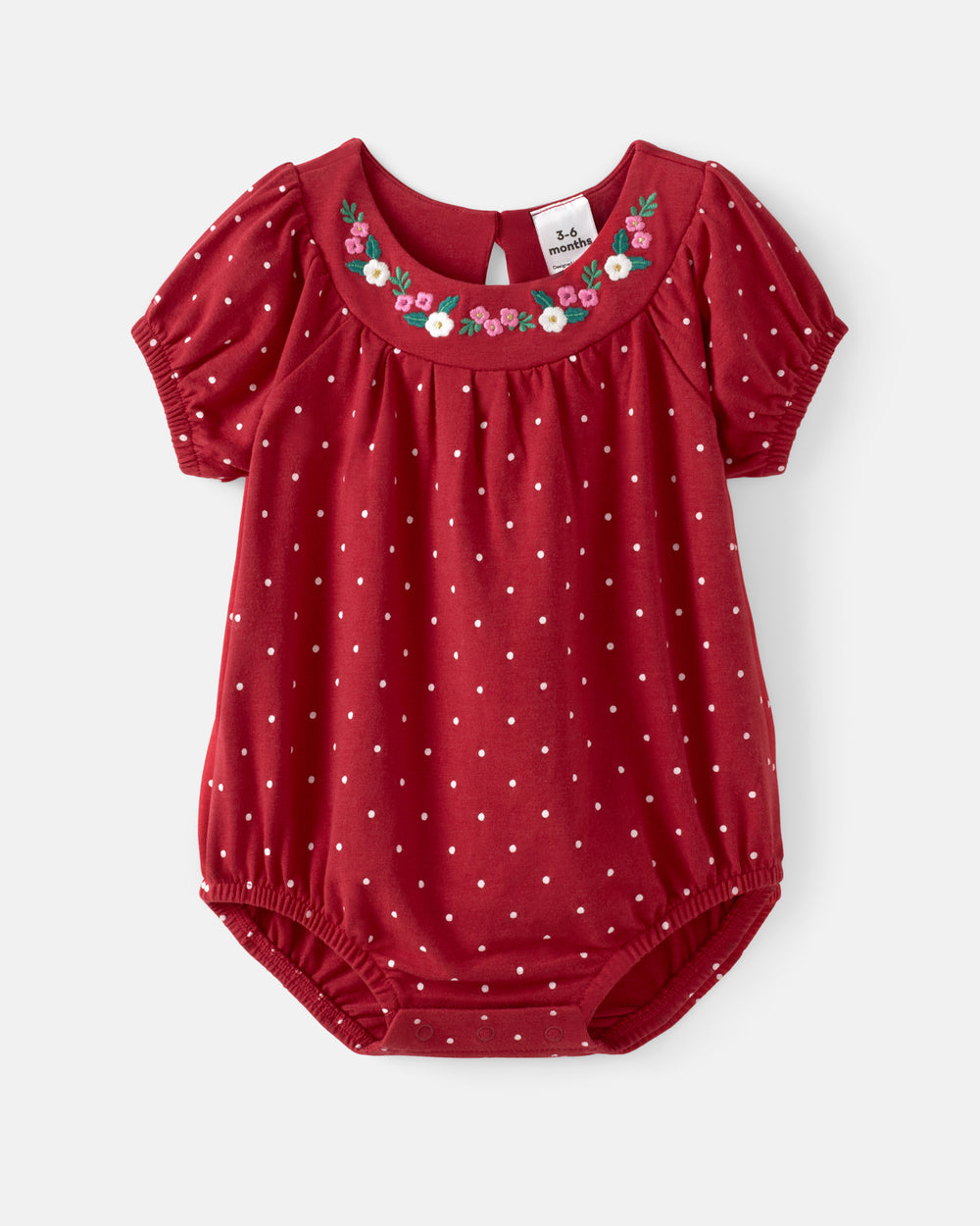 A baby girl's red short-sleeve bodysuit with white polka dots, featuring a floral embroidered neckline and elasticized leg and crotch bands, shown flat on a light gray background.