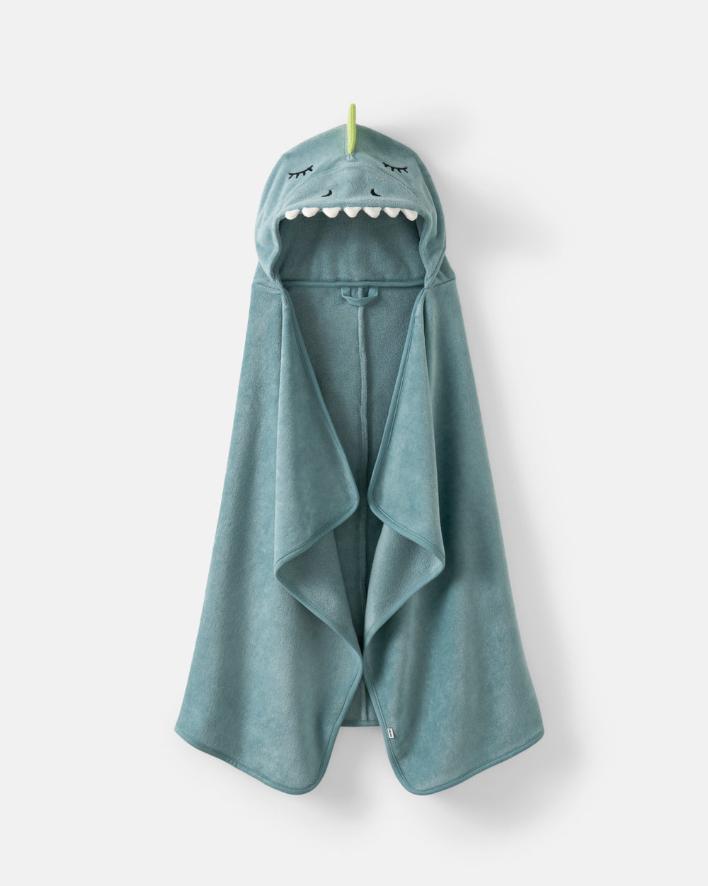 A teal blue hooded towel with a dino face design on the hood, featuring embroidered eyes, nose, and white teeth, hanging against a light gray background.
