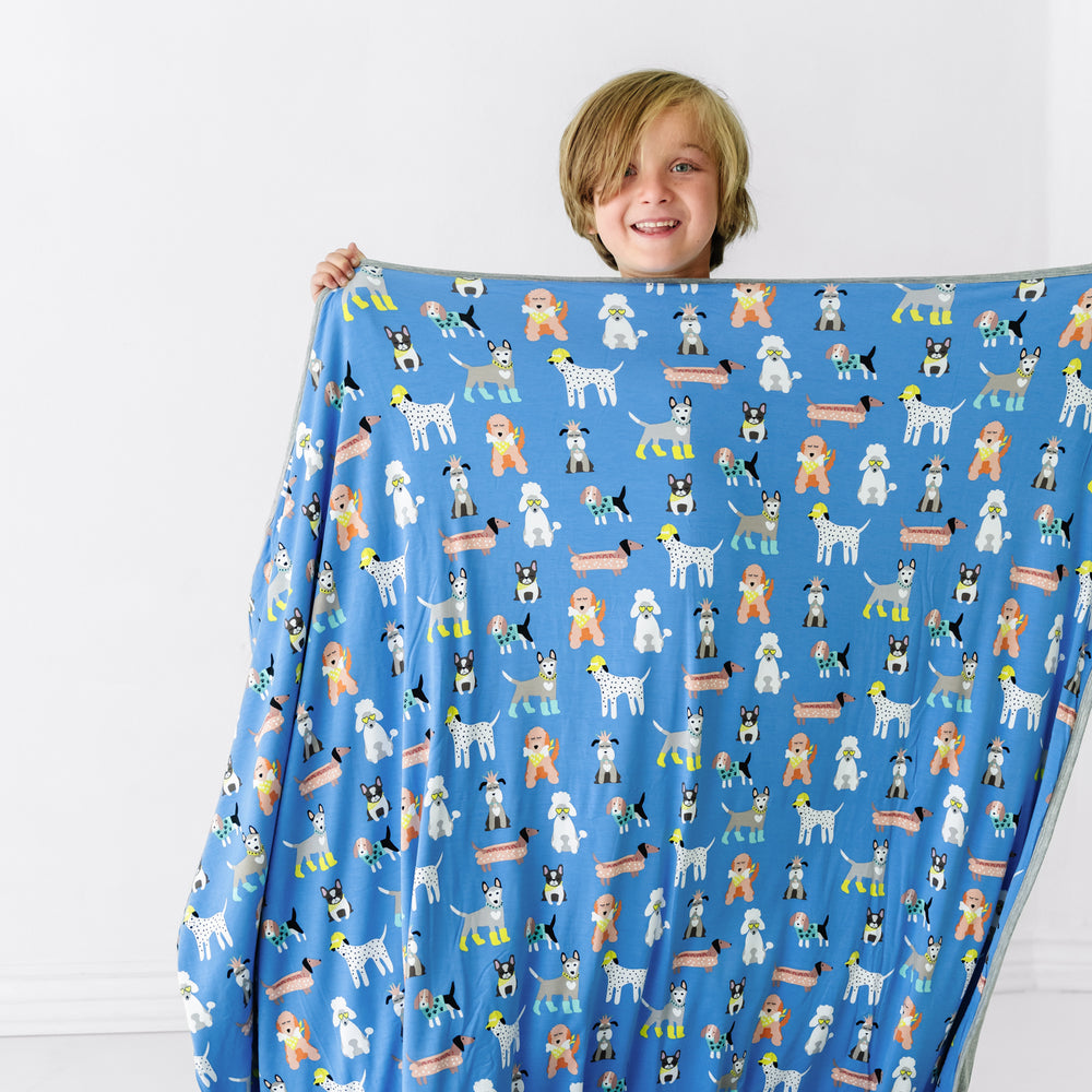Child holding up a Dapper Dogs large cloud blanket