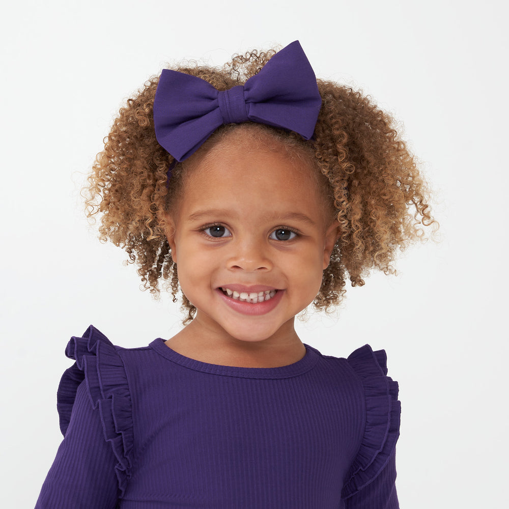 Child wearing a Deep Amethyst luxe bow headband and matching flutter lettuce tee