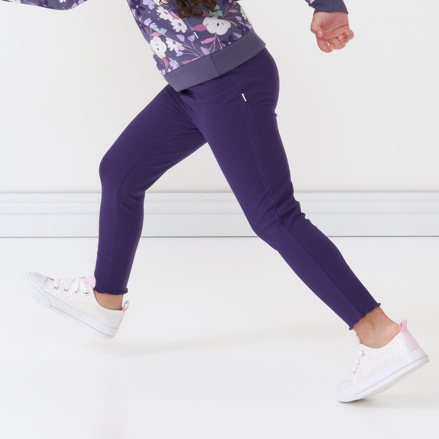 Side view image of a child running wearing Deep Amethyst ribbed lettuce leggings