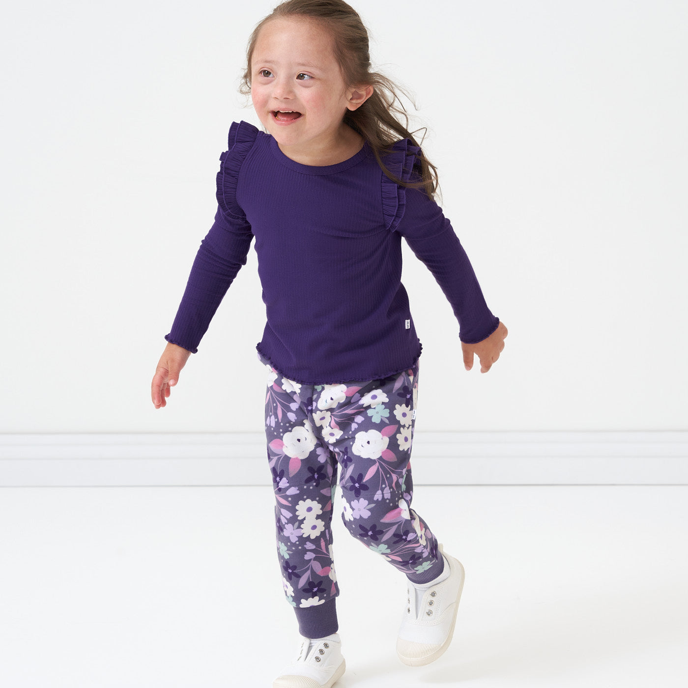 Child wearing a Deep Amethyst ribbed flutter lettuce tee and coordinating Sugar Plum Floral joggers