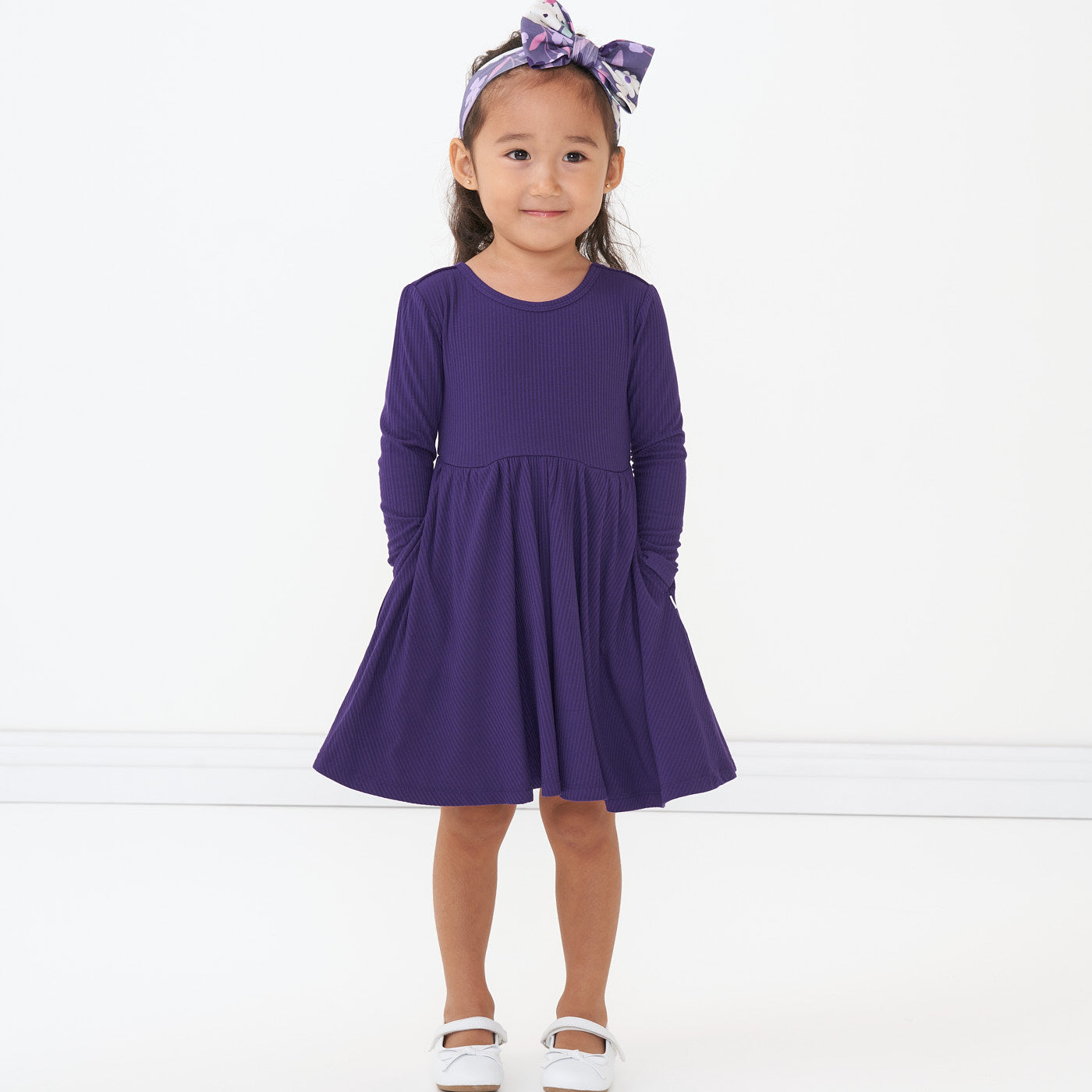 Alternate image of a child wearing a Deep Amethyst ribbed twirl dress and coordinating Sugar Plum Floral luxe bow headband