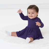 Child sitting on the ground wearing a Deep Amethyst ribbed twirl dress with bodysuit