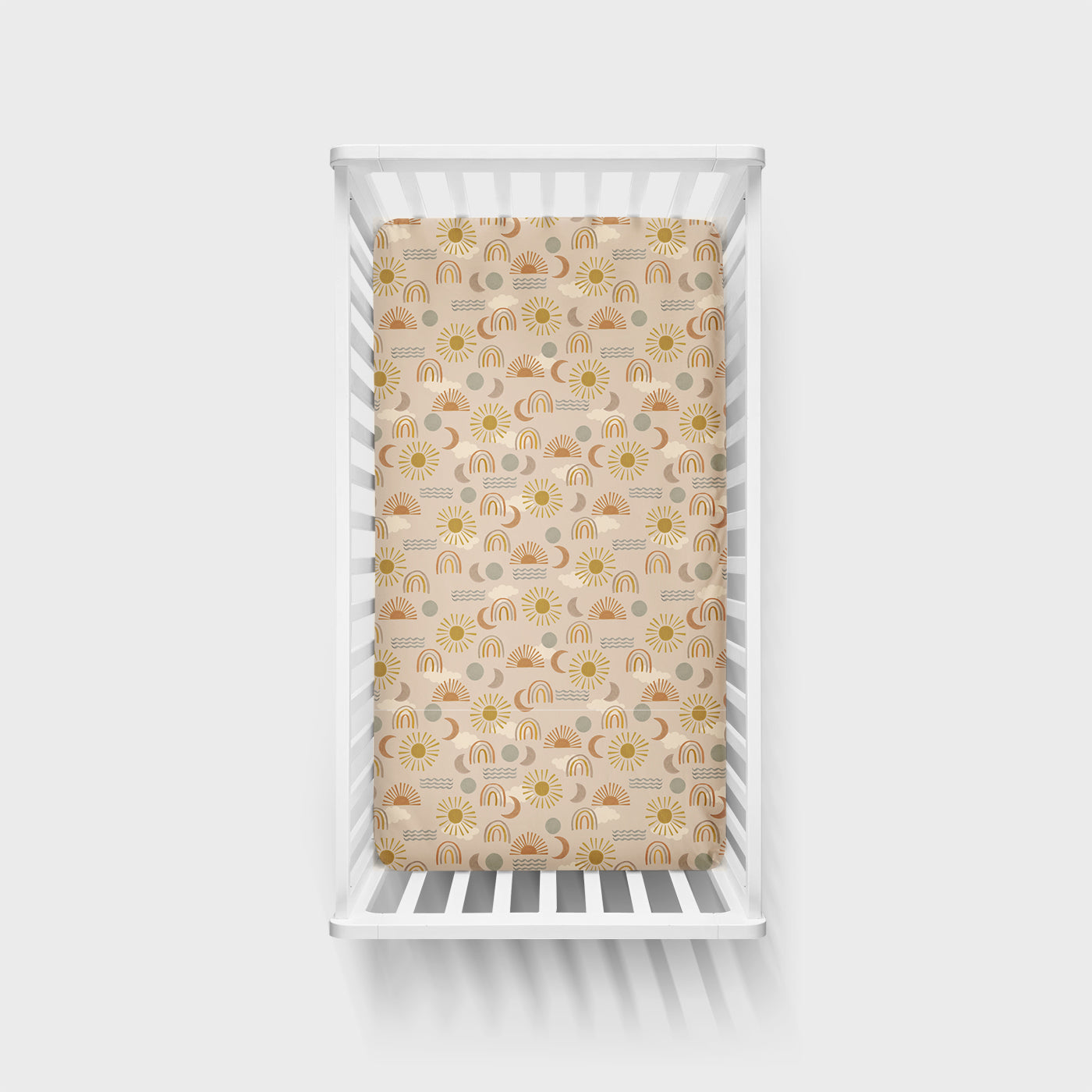 Top view of a Desert Sunrise fitted crib sheet in a white crib