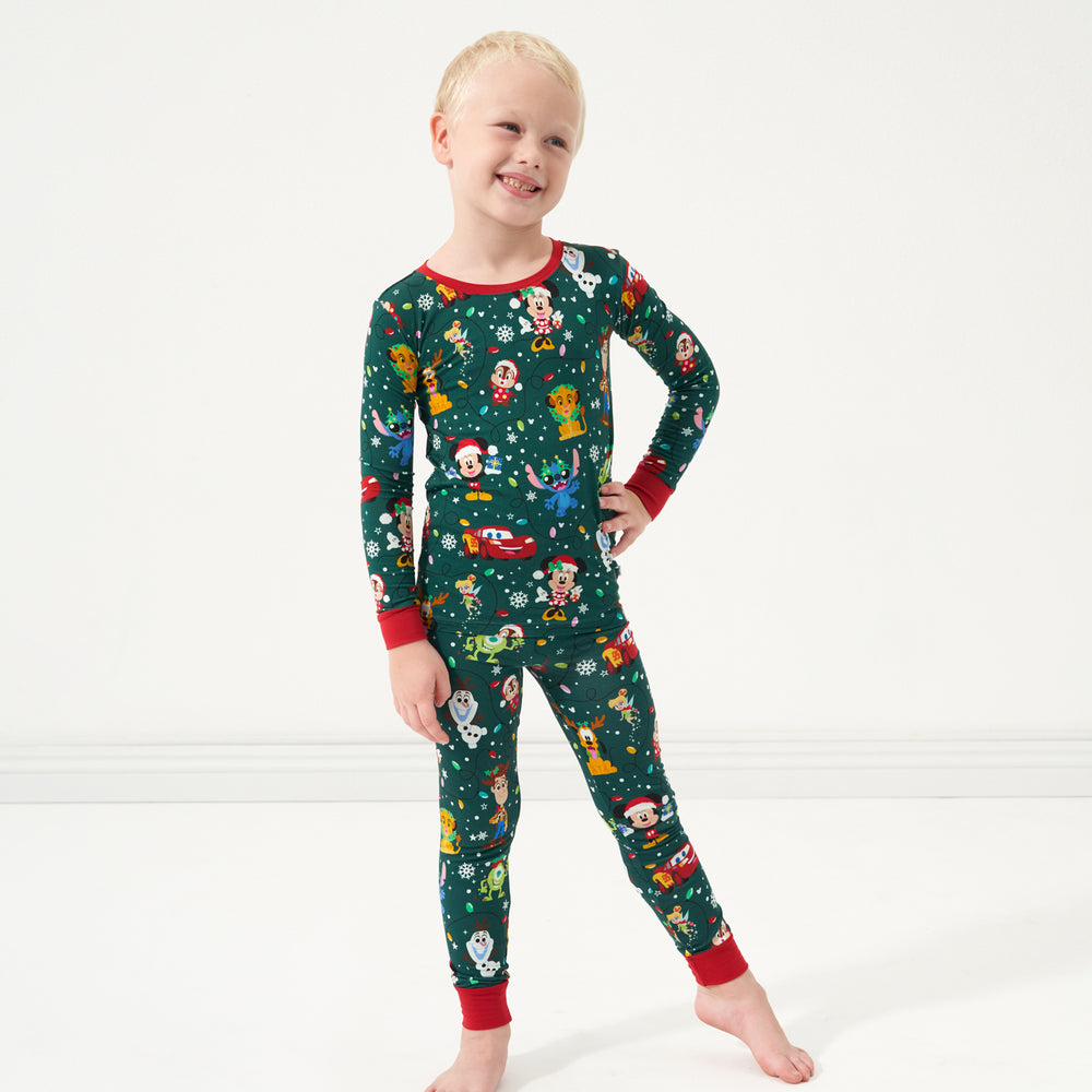 Child with their hand on their hip wearing a Disney Christmas Party two piece pajama set