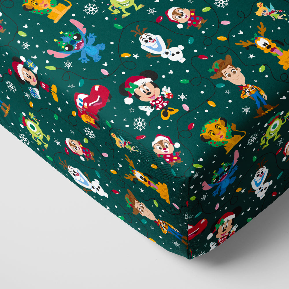 Corner of a mattress with a Disney Christmas Party fitted crib sheet on