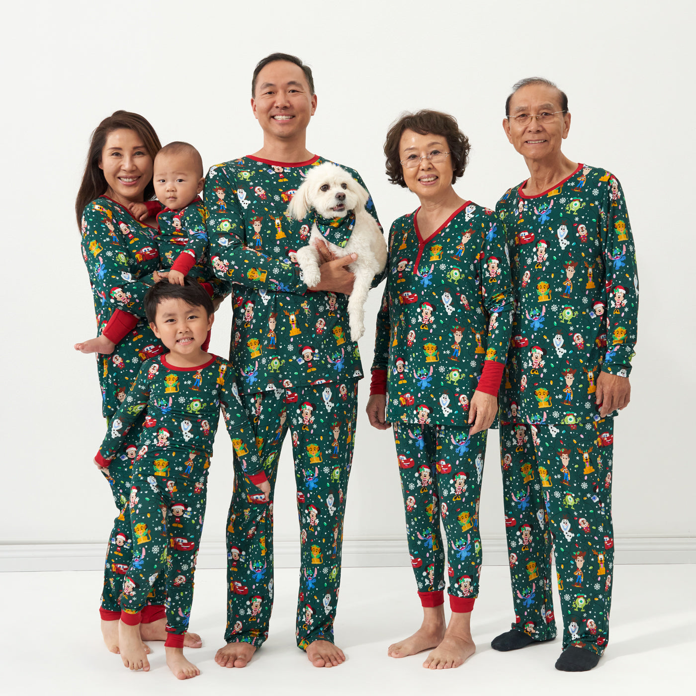 Family and dog wearing matching Disney Christmas Party pajamas and pet bandana