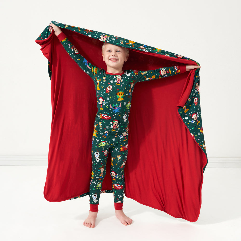 Child holding out a Disney Christmas Party Large Cloud Blanket behind themselves, showing the solid red backing