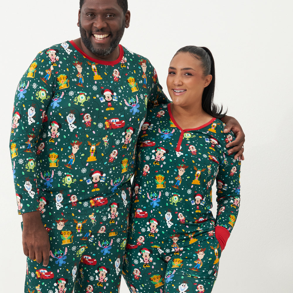 Man and woman wearing matching Disney Christmas Party adult pajamas
