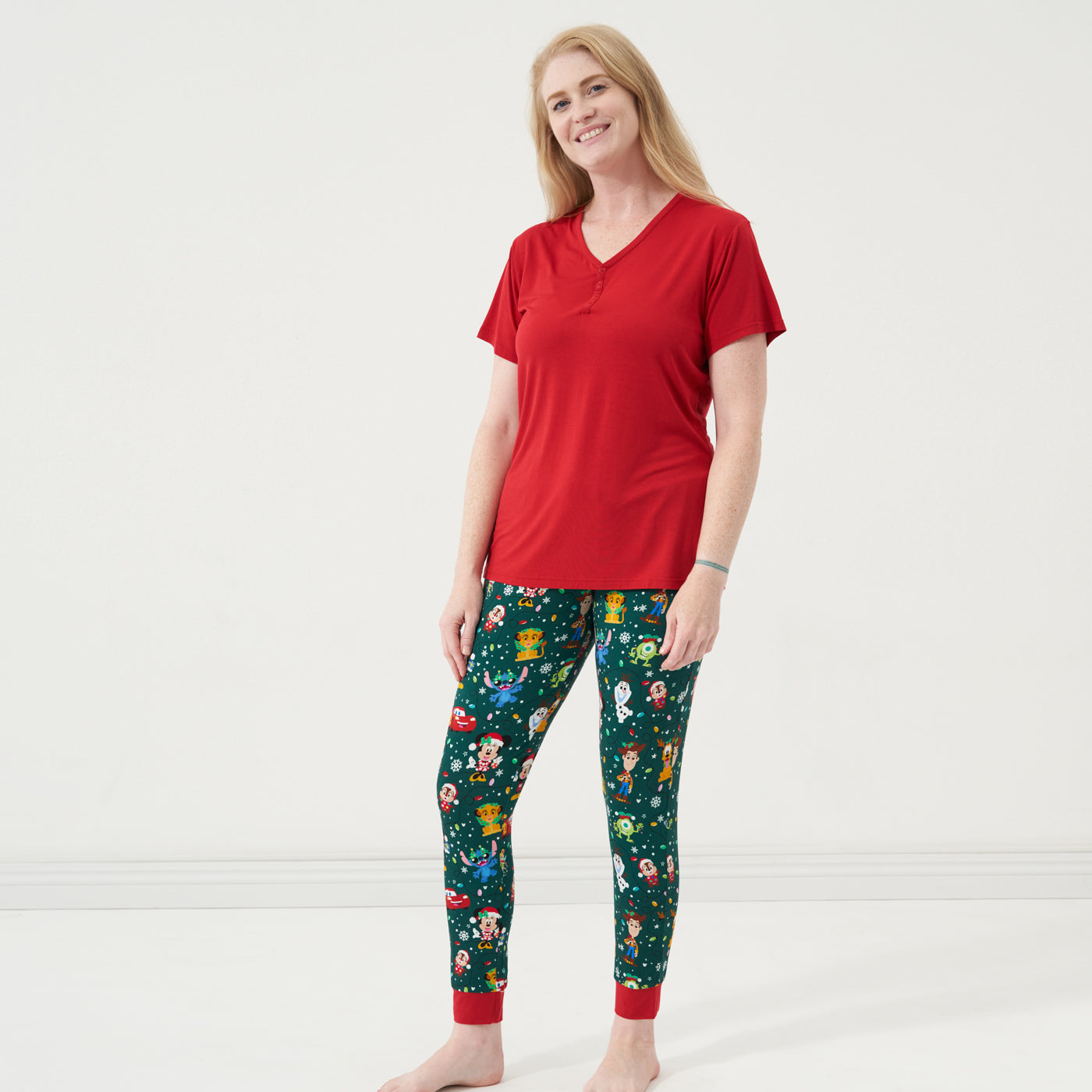 Woman wearing Disney Christmas Party Women's Pajama Pants and coordinating Holiday Red pajama top