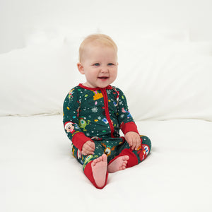 Child sitting on a bed wearing a Disney Christmas Party zippy