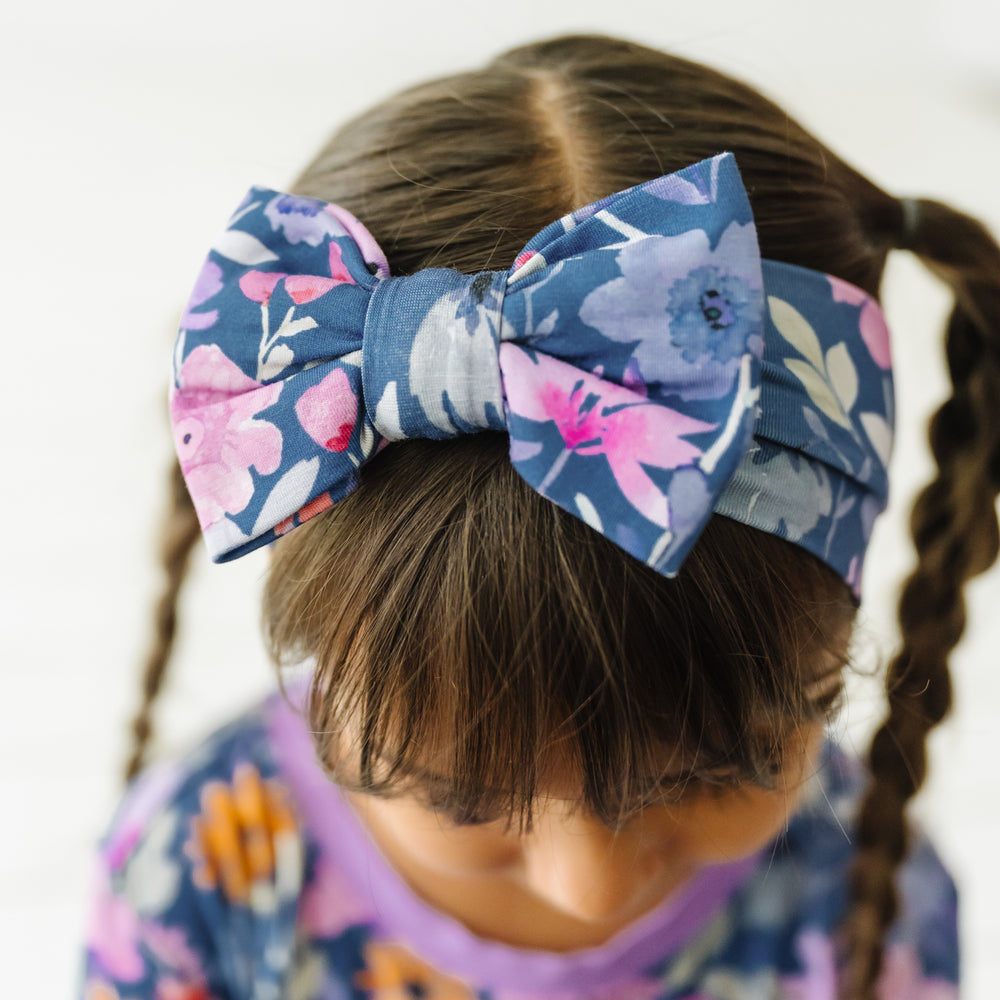 Close up image of a child wearing Dusk Blooms luxe bow headband