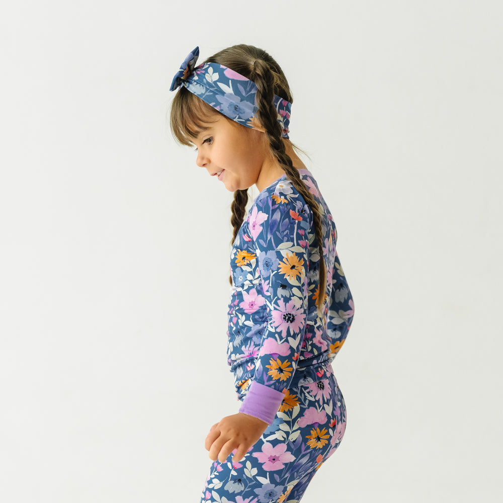 profile view of a child wearing Dusk Blooms two piece pajama set paired with a matching luxe bow headband
