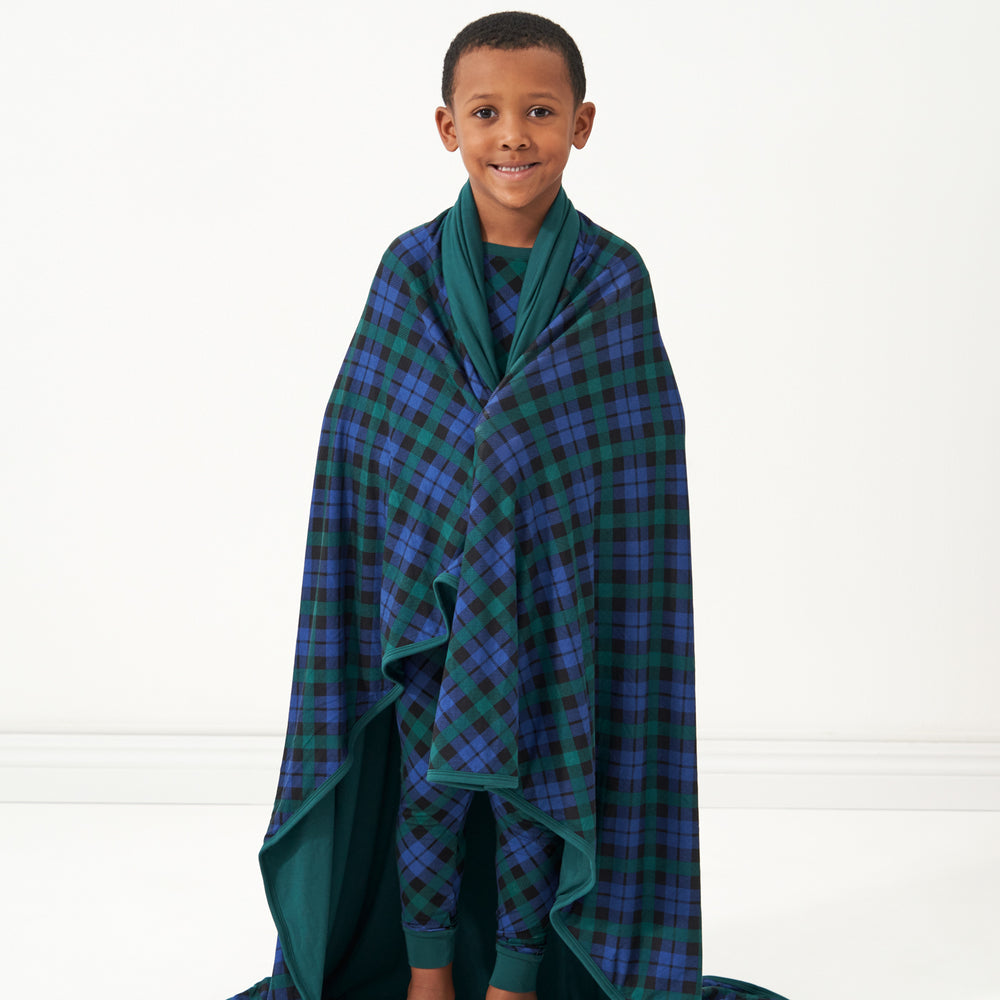 Child wrapped up in an Emerald Plaid large cloud blanket