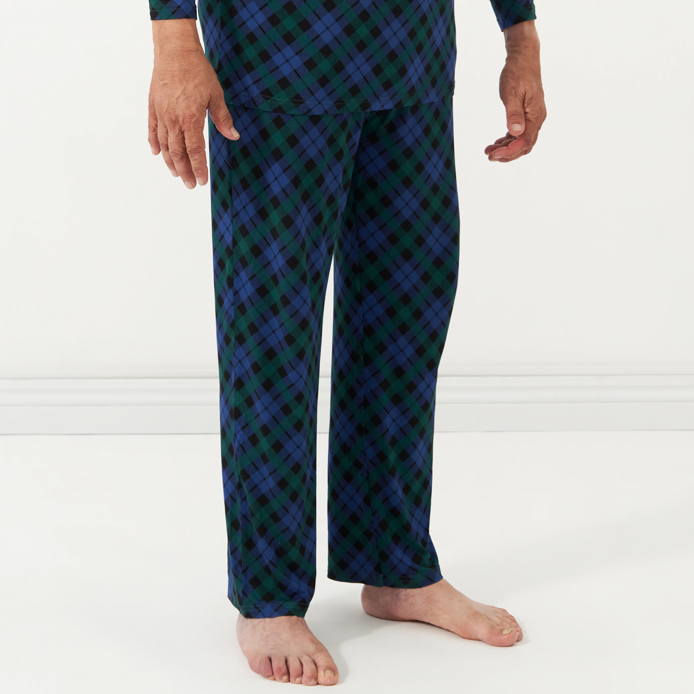 Close up image of a man wearing Emerald Plaid men's pajama pants