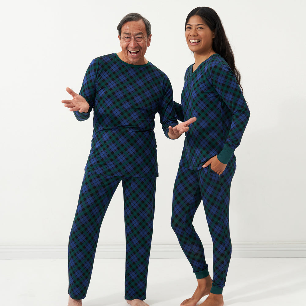 Man and woman wearing matching Emerald Plaid pajamas