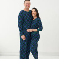 Man and woman wearing matching Emerald Plaid pajamas
