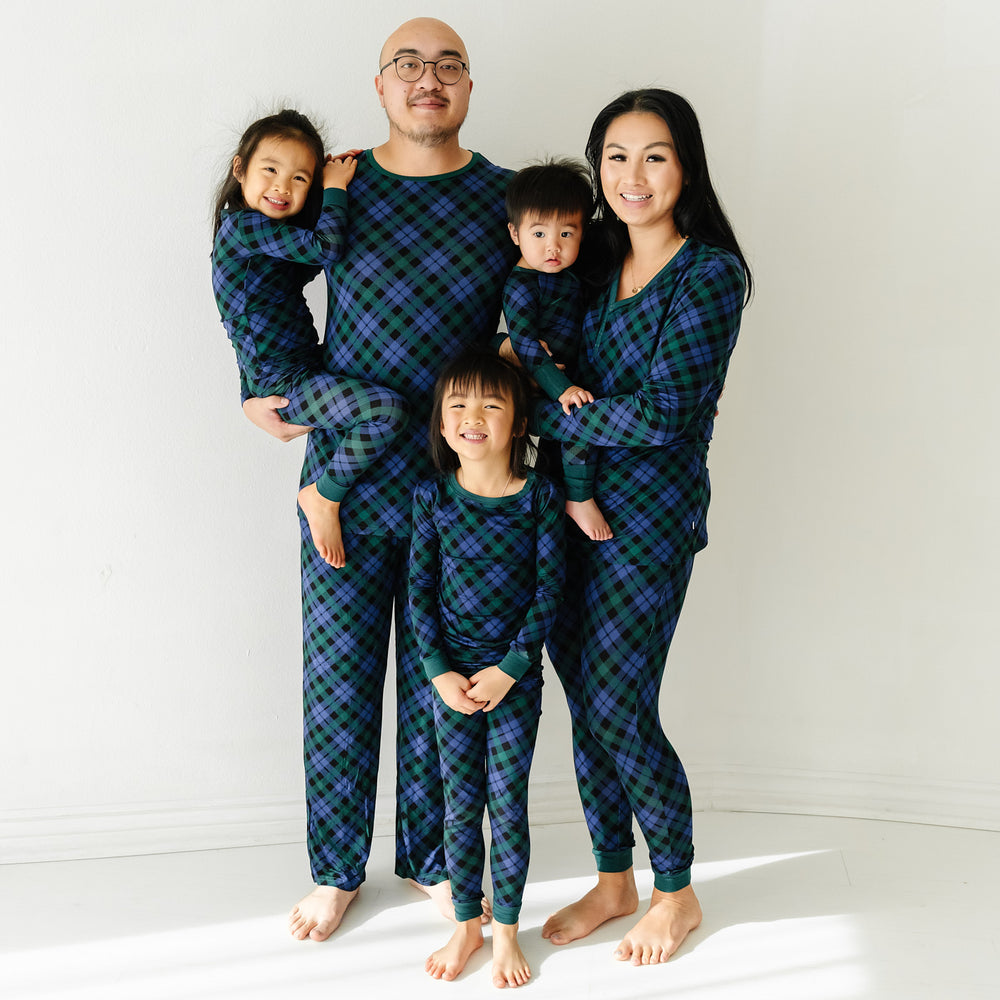 Family of five wearing Emerald Plaid matching pajamas in men's, women's, and children's two piece and zippy styles