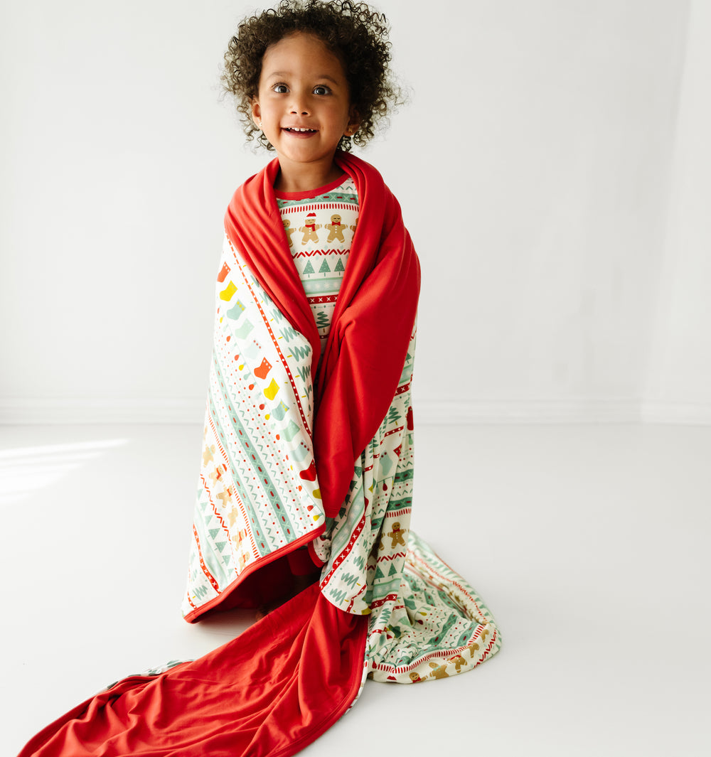 Child wrapped up in a Fair Isle large cloud blanket wearing matching pajamas