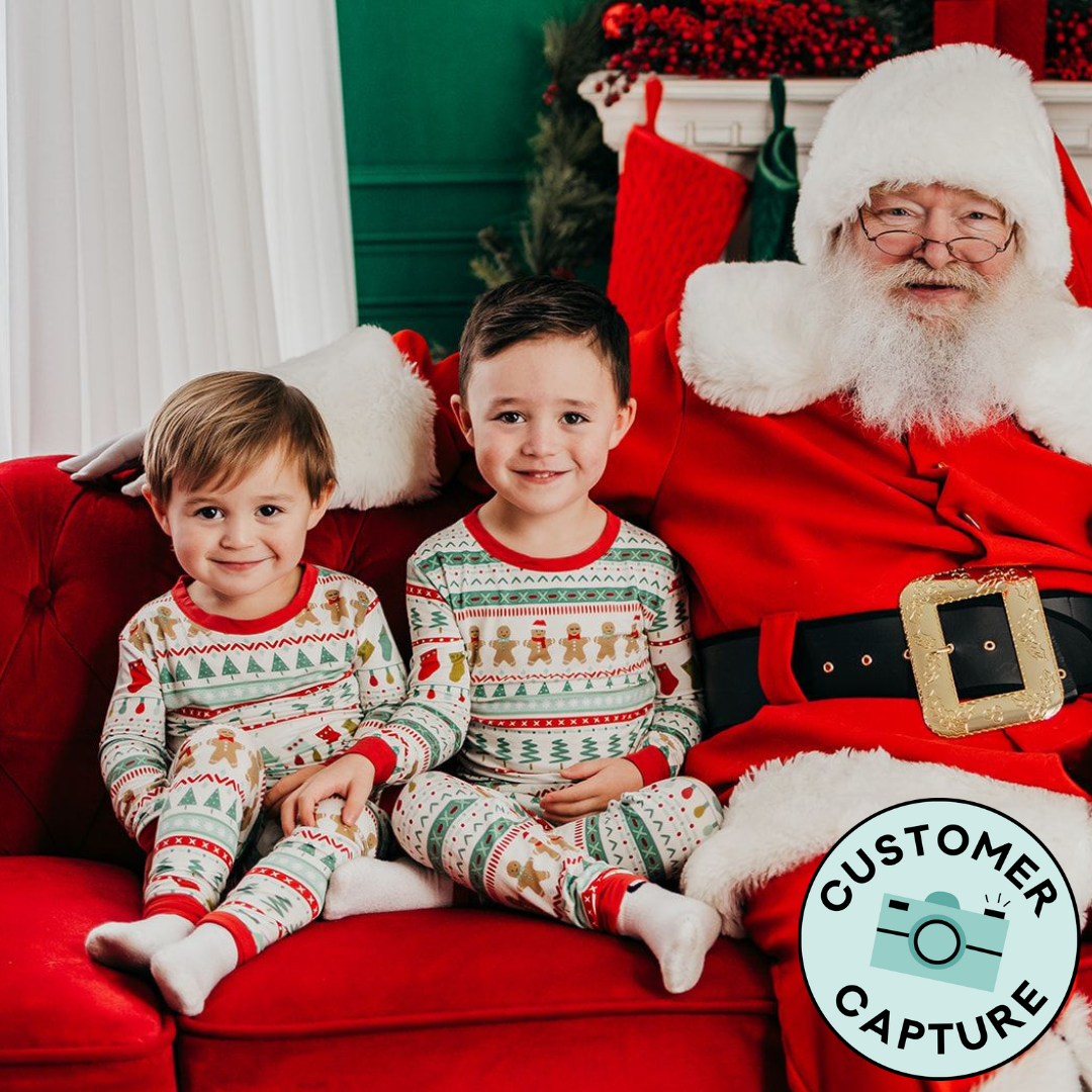Customer Capture image of two children sitting with Santa wearing Fair Isle two piece pajama sets