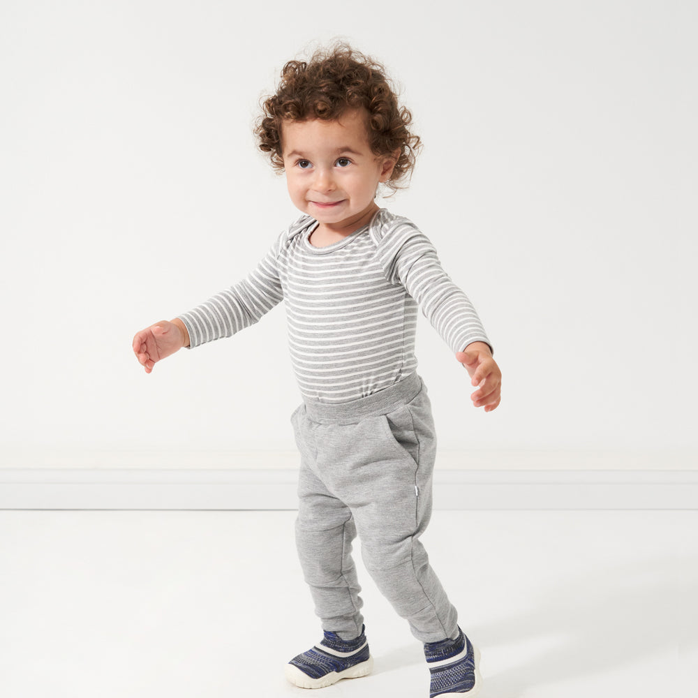 Click to see full screen - Child wearing a Heather Gray and Ivory Stripe Bodysuit paired with Heather Gray joggers