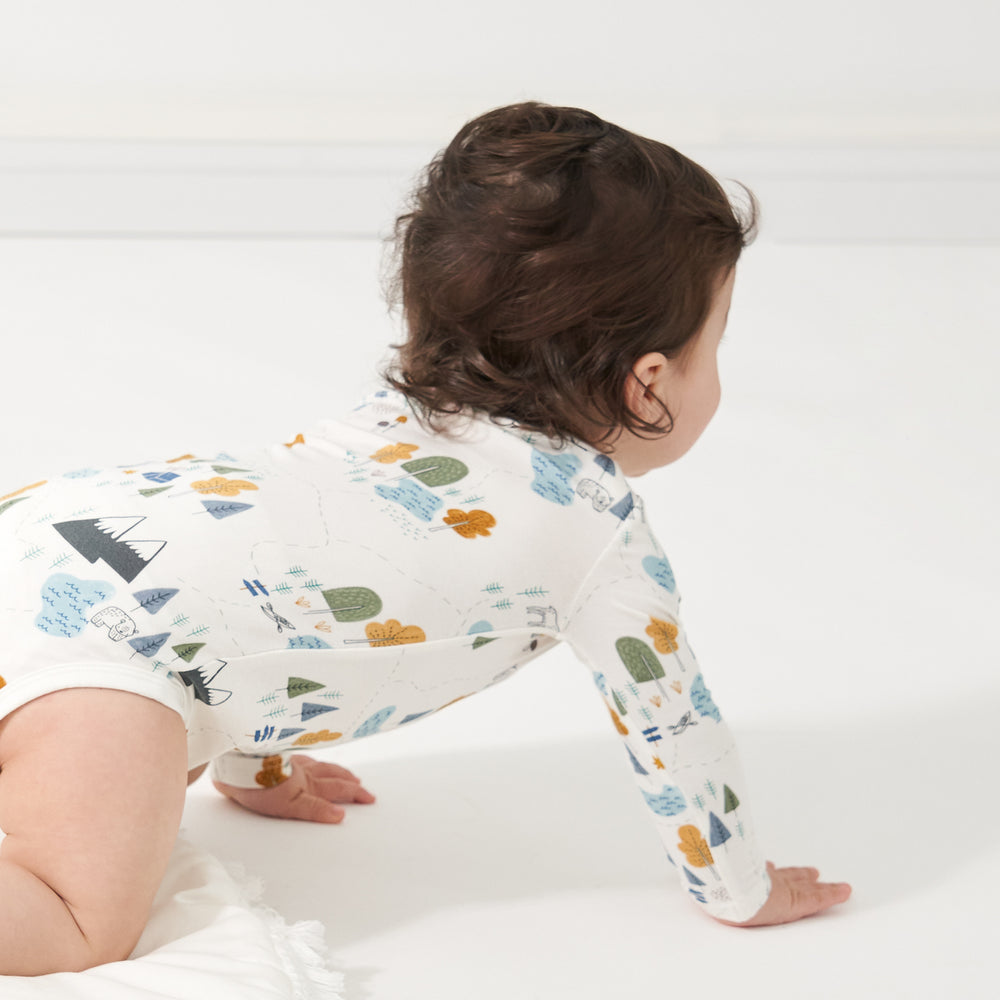 Close up image of a child crawling wearing a Let's Explore bodysuit