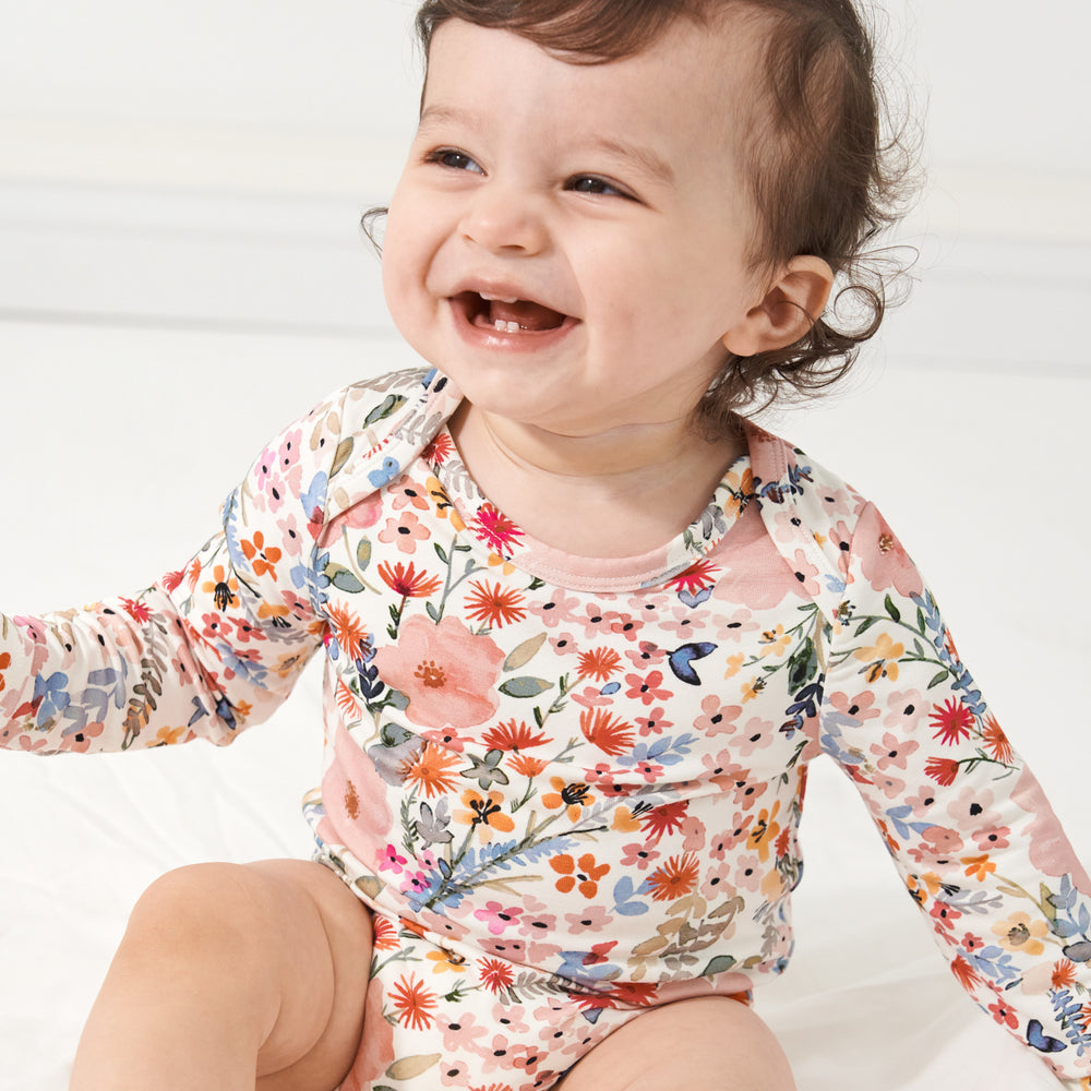 Close up image of a child wearing a Mauve Meadow printed bodysuit