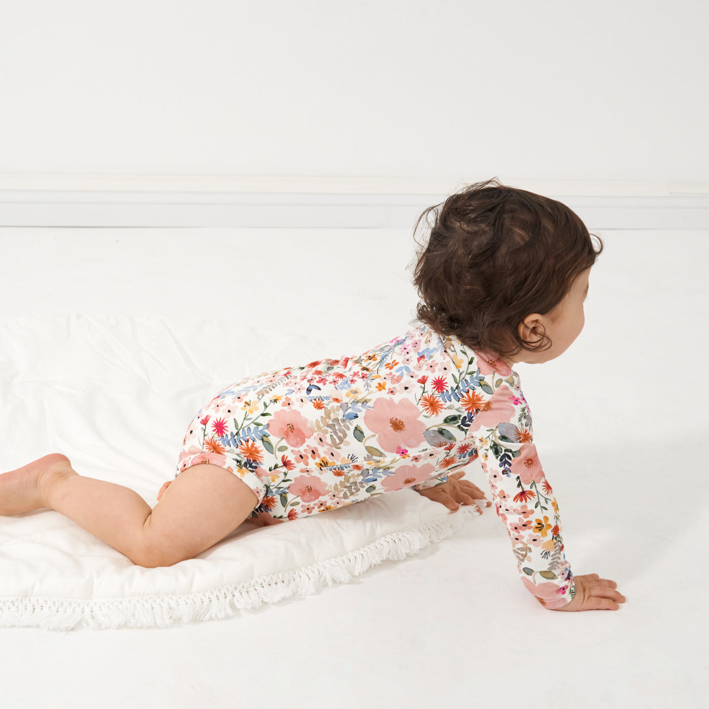 Child crawling wearing a Mauve Meadow printed bodysuit