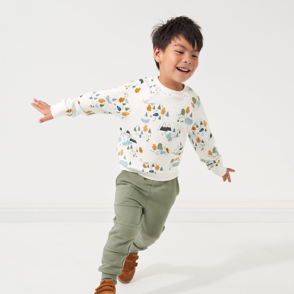 Child running wearing a Let's Explore printed crewneck sweatshirt