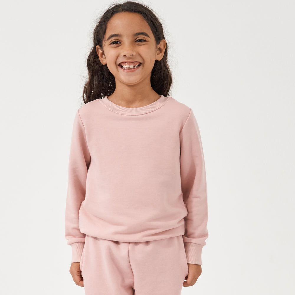 Child wearing a Mauve Blush crewneck paired with matching Mauve Blush paperbag joggers
