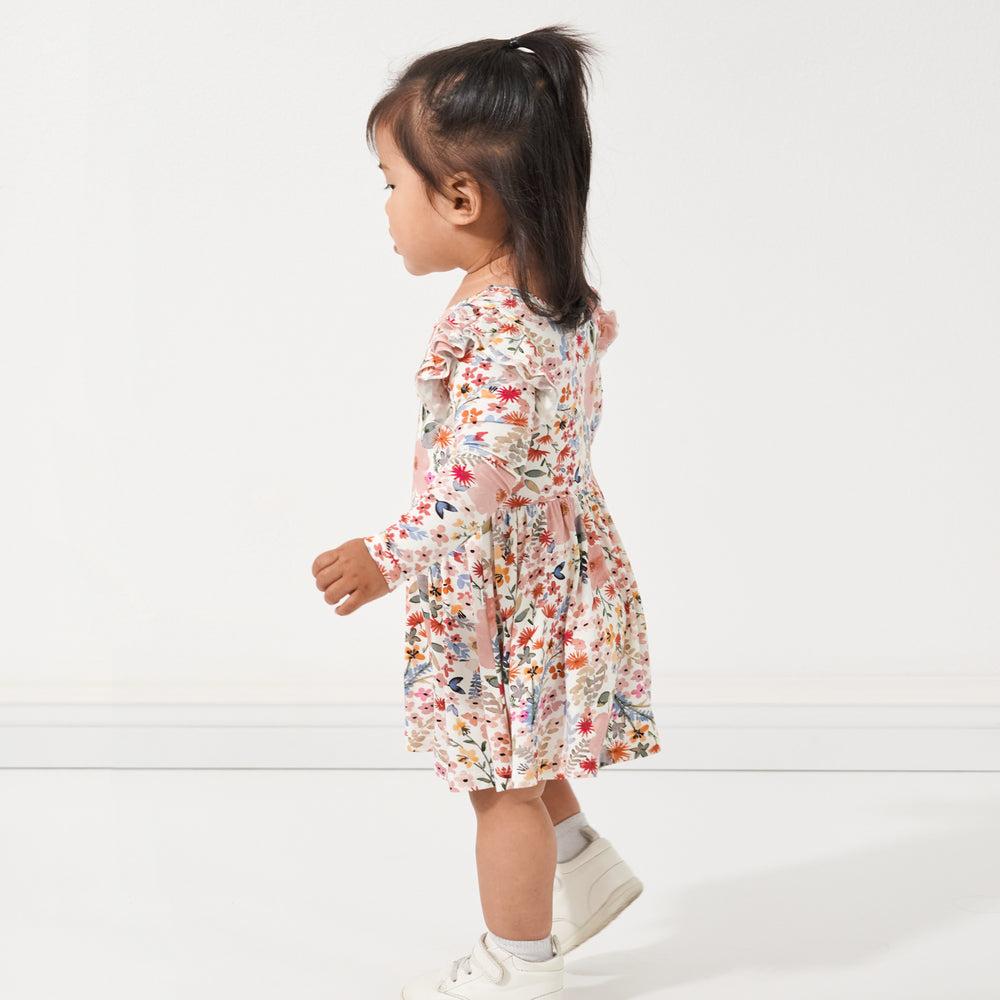 Profile view of a child wearing a Mauve Meadow twirl dress with bodysuit