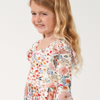 Close up image of a child wearing a Mauve Meadow twirl dress focusing on the flutter sleeves