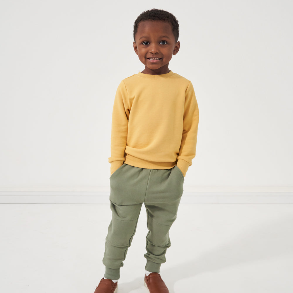 Child wearing Moss joggers and a coordinating Honey elbow patch crewneck