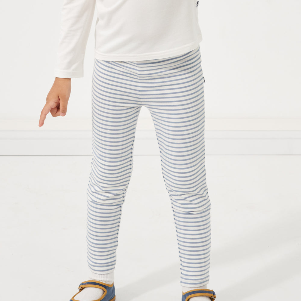 Child wearing Ivory and Fog Stripe leggings paired with an Ivory classic tee