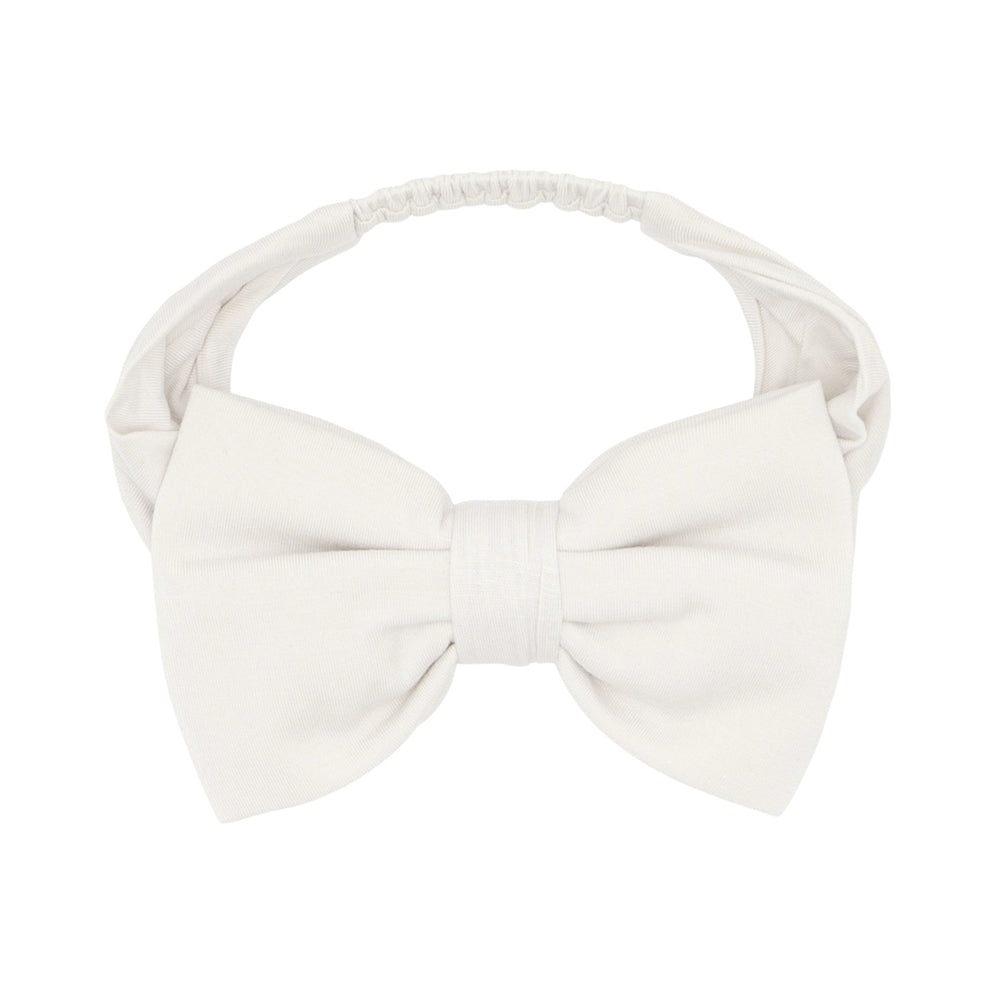 Click to see full screen - Flat lay image of an Ivory luxe bow headband in sizes age 4 to age 8