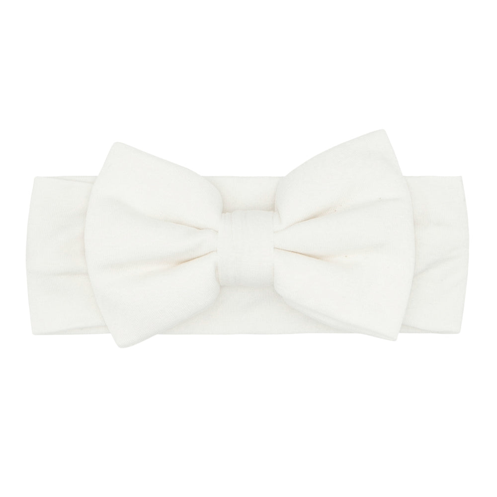 Click to see full screen - Flat lay image of an Ivory luxe bow headband age newborn to 3T