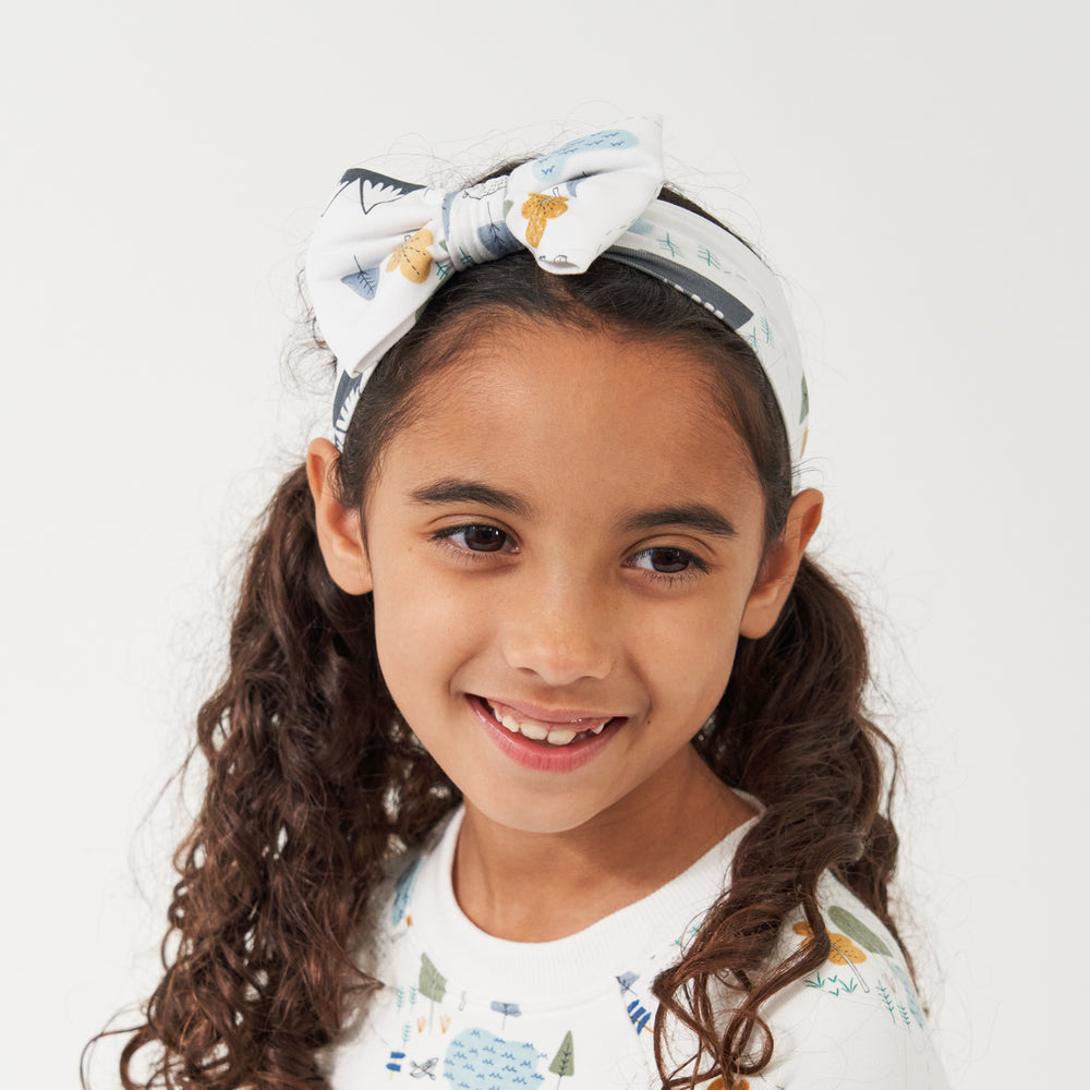 Click to see full screen - Alternate close up image of a child wearing a Let's Explore printed luxe bow headband