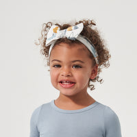 Child wearing a Let's Explore printed luxe bow headband