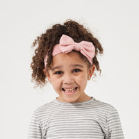 Alternate image of a child wearing a Mauve Blush luxe bow headband paired with a Heather Gray Striped classic tee