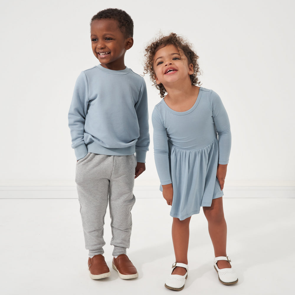 Click to see full screen - Two children wearing coordinating outfits from Play by Little Sleepies in Fog and Gray