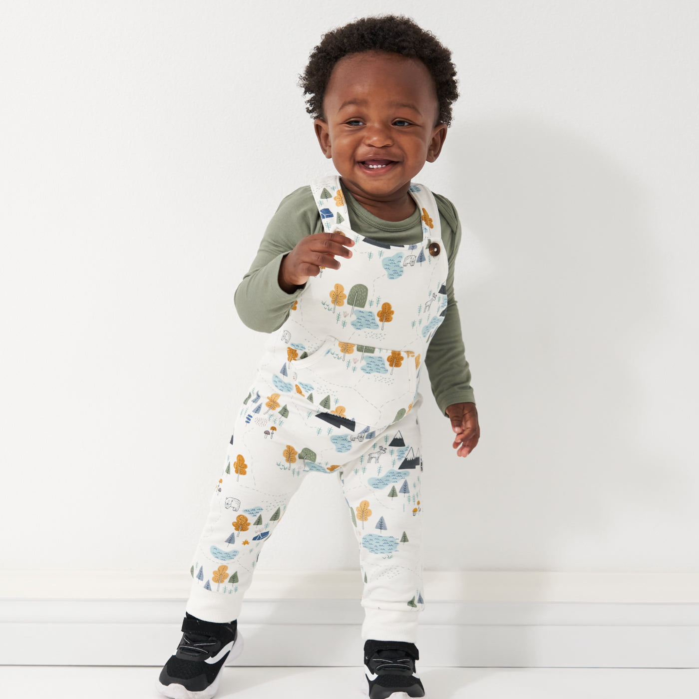 Child wearing Let's Explore printed overalls