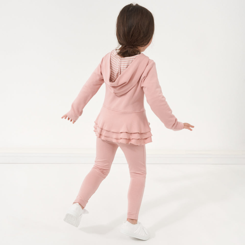 Backside view of a child wearing a Mauve Blush peplum hoodie paired with matching Mauve Blush leggings